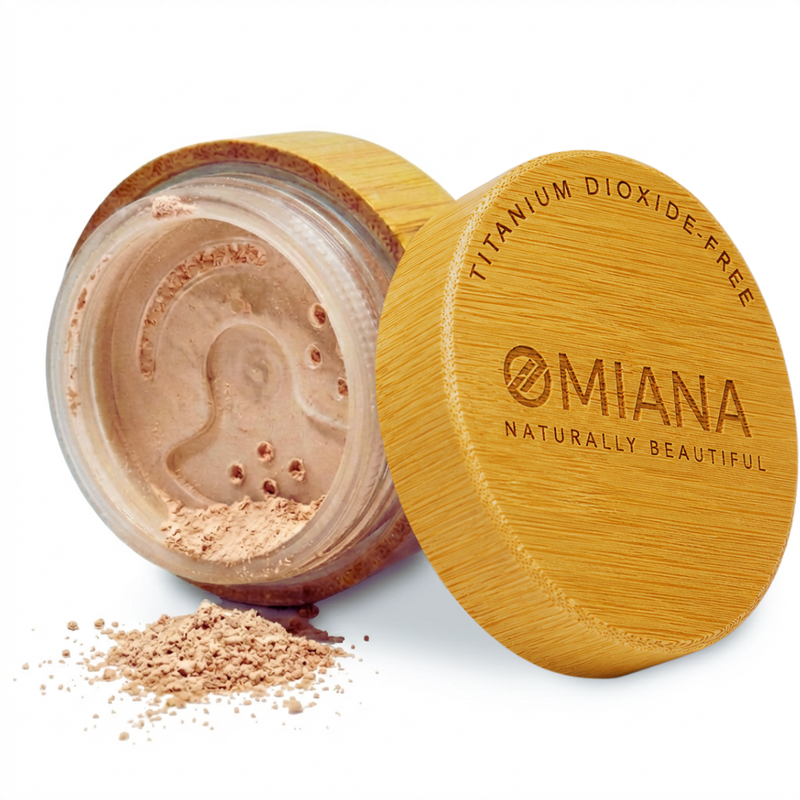 Open container of Omiana Mineral Loose Powder Makeup for sensitive skin with visible brand name on a white background